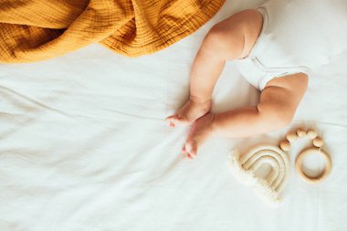 Baby playing with a wooden toy. Top view. Copy space.