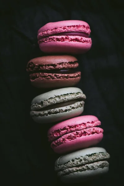 Macaroons on dark background, colorful french cookies macaroons. Macaroons in a row. Top view. Close-up. High quality photo.