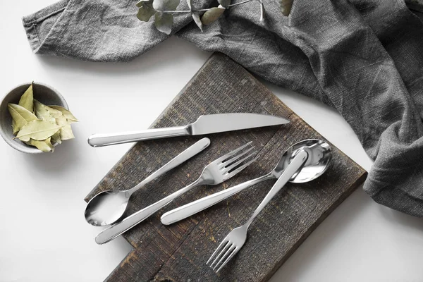 Çatal bıçak takımı - çay kaşığı, yemek kaşığı, tatlı çatalı, masa çatalı ve masa bıçağı beyaz arka planda. Güzel gümüş çatal bıçak takımı. Gri yüzeyde paslanmaz çelik çatal bıçak seti. Stüdyo ürün fotoğrafçılığı.