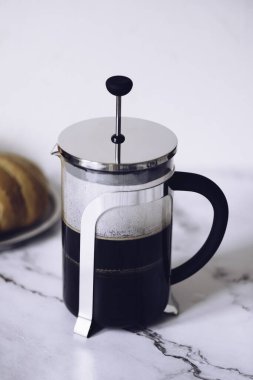 Filtre damlatıcıyla kahve yapmak. Kağıt filtreden damlayan kahve. Kahve yapmak için alternatif bir yol. Makro yakın çekim. Siyah arka planda cam çaydanlıktan beyaz fincana kahve dökülüyor..