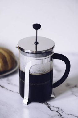 Filtre damlatıcıyla kahve yapmak. Kağıt filtreden damlayan kahve. Kahve yapmak için alternatif bir yol. Makro yakın çekim. Siyah arka planda cam çaydanlıktan beyaz fincana kahve dökülüyor..