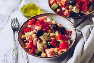 Domatesli zengin protein Yunan salatası, dolma biber, salatalık, siyah zeytin, peynir, soğan ve nohut. Sebze salatası. Vejetaryen lezzetli yemek tarifi. Bitki temelli menü. Üst görünüm.