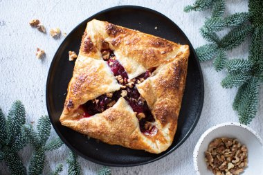 Fırınlanmış krem peynir ve kızılcıklı börek. Ev yapımı puf böreği, tatlı-lezzetli tat, gurme aperatif tarifi. Camembert peyniri ve kızılcık soslu puf böreği. Yakın plan..