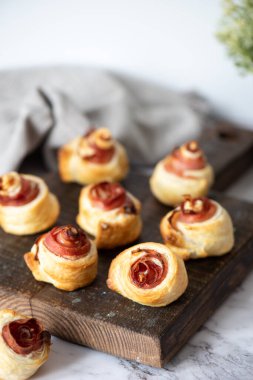 Puf böreği kıvrımları. Nefis poğaçalı hamur tatlısı ve prosciutto yakın plan. Gurme aperatif tarifi fikri. Yüksek kalite fotoğraf.