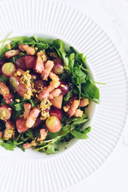 Tasty salad with arugula, grapes, bacon and fennel seeds. Fat keto recipe. Gourmet tasty food recipe for cook book. Top view. clipart