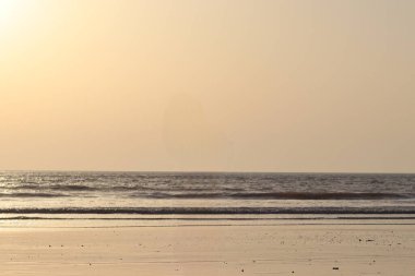 Akşamları okyanus dalgaları olan sessiz bir sahil.