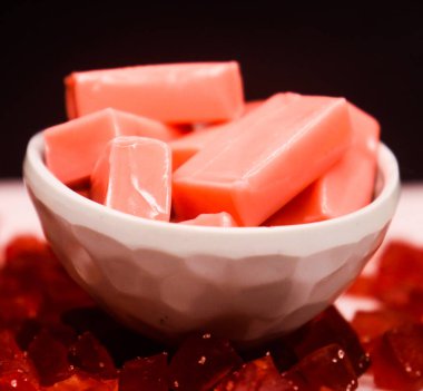 Siyah arka planda bir kasede lezzetli meyve şekeri