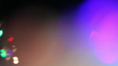 Siyah Arkaplanda Çok Renkli Işık Sızıntısı 4K Görüntüsü. Lens Stüdyosu Fişek Patlaması. Doğal Işıklandırma Lambası Bokeh Etkisi. Birleşim, Video Biçimlendirme ve Geçişler için mükemmel.