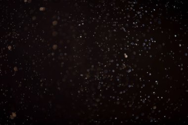 Yüzen parçacıklar. Yüzen toz. Ateş parçacıkları. Siyah arkaplan üzerindeki parçacıklar.