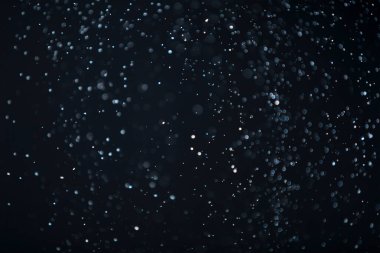 Yüzen parçacıklar. Yüzen toz. Ateş parçacıkları. Siyah arkaplan üzerindeki parçacıklar.