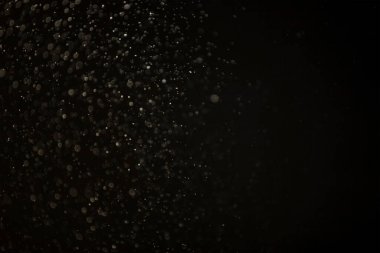 Yüzen parçacıklar. Yüzen toz. Ateş parçacıkları. Siyah arkaplan üzerindeki parçacıklar.