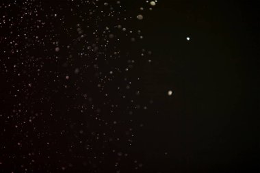 Yüzen parçacıklar. Yüzen toz. Ateş parçacıkları. Siyah arkaplan üzerindeki parçacıklar.