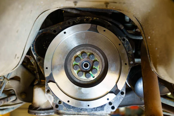 Bir tamirhanedeki Flywheel debriyajını kapat. Tekerlekli debriyaj plakasını bakım kamyonuna yerleştir. Tamirci vites ve debriyajı tamir ediyor..
