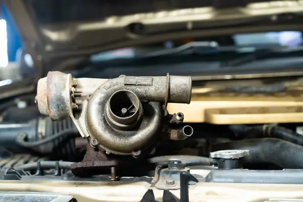 Oto tamir atölyesindeki eski araba motorunun eski Turbo 'sunu kapat, seçici odaklanma. Motordan kopmuş turbo.