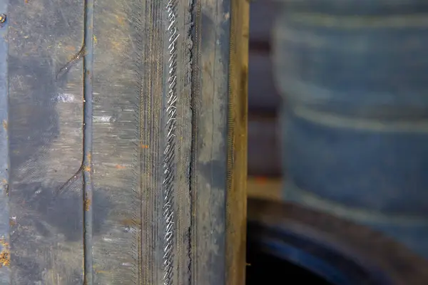 Garajdaki eski araba lastiği, seçici odaklı fotoğrafa yakın çekim. Lastikler hasar görmüş ve süresi geçmiş. Eğer bir kablo görürseniz, hemen değiştirilmeleri gerekir..