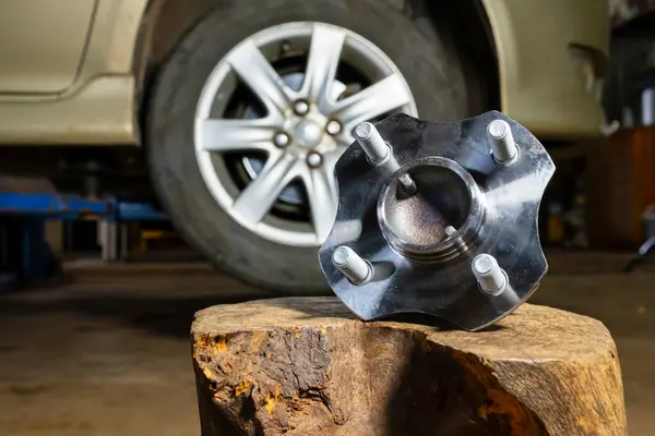 Tamirci tekerlek millerini değiştiriyor. Tekerlek taşıyıcısı kırılmış ve tamirci tamir ediyor..