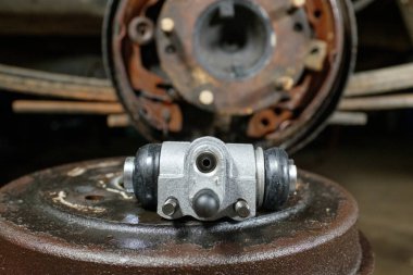 Yeni araba freni köle silindiri. Tamirci araba fren sistemini tamir ediyor. Atölyedeki masada eski araba parçaları var. Seçici odak.