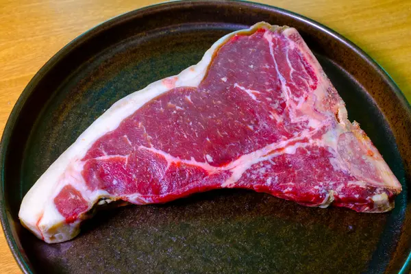 Tbone mermer biftek. Bir parça çiğ bifteğe yakın. Pişirmeye hazır taze biftek.