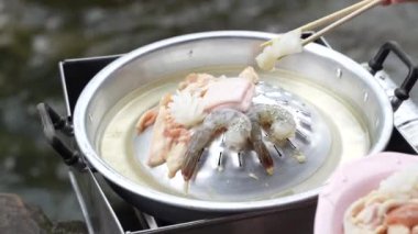 Çubuklar tavada dilimlenmiş domuz eti ve sığır eti topluyor. Thai BBQ Mookata.