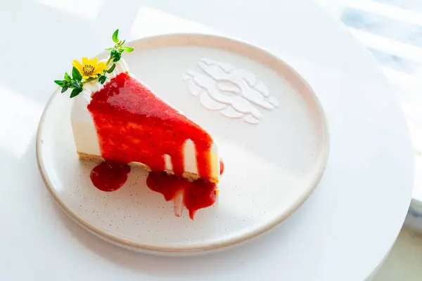 Beyaz tabakta çilekli kek. En sevdiğin fırının olduğu sabah kafesi. Seçmeli odak noktası.