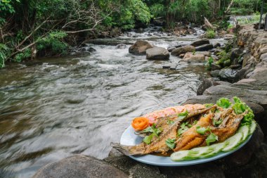 Deep Fried Sea Bass with Fish Sauce background stream has flowing water, Fried Fish, Thai style, spicy mango sauce, Pla Tod Num pla clipart