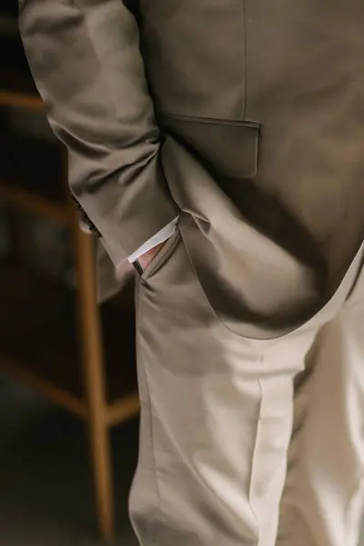 Erkek kahverengi pantolonu, lüks kahverengi formülü, takım elbiseli bir işadamı kravatını düzeltir, klasik bir ofis modası.,