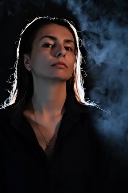 Karanlıktaki bir kızın silueti. Duman. Buhar. Karanlık bir odadaki kız.