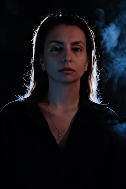 Karanlıktaki bir kızın silueti. Duman. Buhar. Karanlık bir odadaki kız.