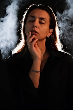Karanlıktaki bir kızın silueti. Duman. Buhar. Karanlık bir odadaki kız.