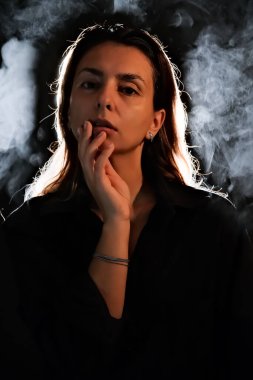 Karanlıktaki bir kızın silueti. Duman. Buhar. Karanlık bir odadaki kız.