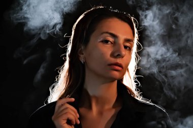 Karanlıktaki bir kızın silueti. Duman. Buhar. Karanlık bir odadaki kız.