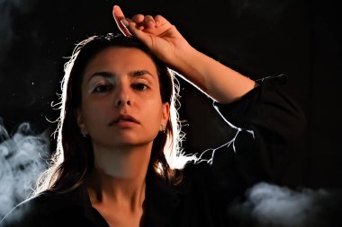 Karanlıktaki bir kızın silueti. Duman. Buhar. Karanlık bir odadaki kız.