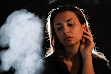 Karanlıktaki bir kızın silueti. Duman. Buhar. Karanlık bir odadaki kız.
