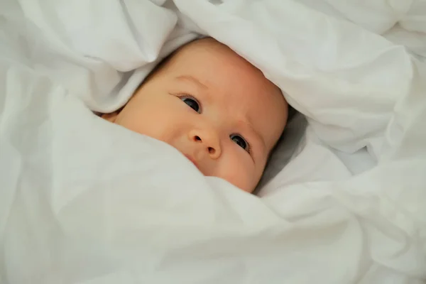 ทารกแรกเก มและห วเราะ แสดงอารมณ กนอนบนผ าขาว — ภาพถ่ายสต็อก