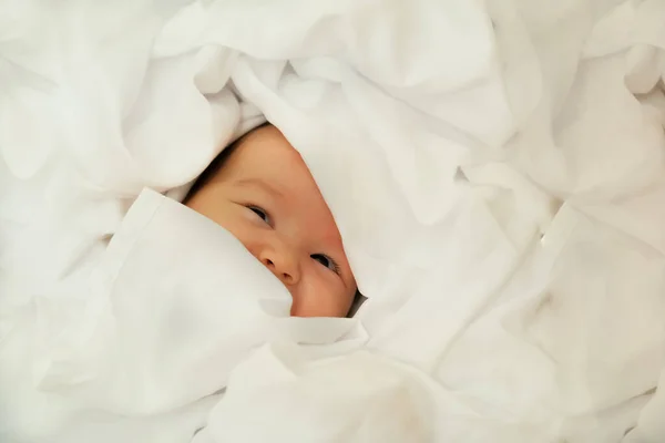 新生児の笑顔と笑い 感情を表す 赤ちゃんは白い布の上に — ストック写真