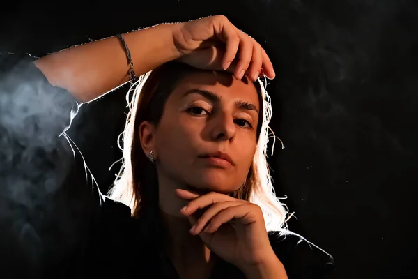 stock image silhouette of a girl in the dark. smoke . steam . girl in a dark room.