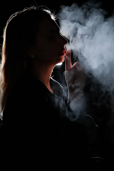 stock image silhouette of a girl in the dark. smoke . steam . girl in a dark room.