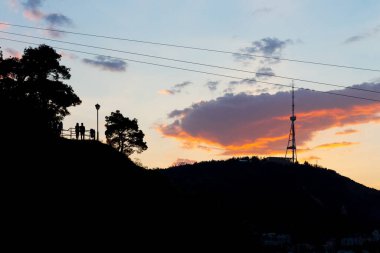 Gün batımında Tiflis 'te TV kulesi olan tepelerin siluetleri. Gürcistan