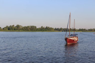 Gün batımında Kherson 'daki Dnipro nehrinin ortasında bir yelkenli yat. Ukrayna. 30 Haziran 2019