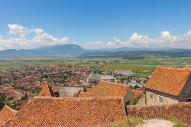 Transilvanya dağlarındaki ortaçağ kalesi Rasnov Kalesi 'nin bölgesinden Rasnov şehri manzarası. Romanya