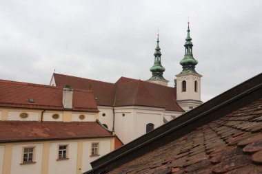 Bulutlu bir sabahta çatılar ve St. Michael Kilisesi manzarası. Çek Cumhuriyeti
