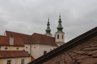 Bulutlu bir sabahta çatılar ve St. Michael Kilisesi manzarası. Çek Cumhuriyeti