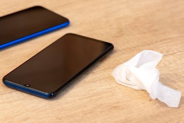 Islak dezenfektan, peçete. Cep telefonu. Akıllı telefon çantasının dezenfekte edilmesi, virüslerin ve baterinin yok edilmesi