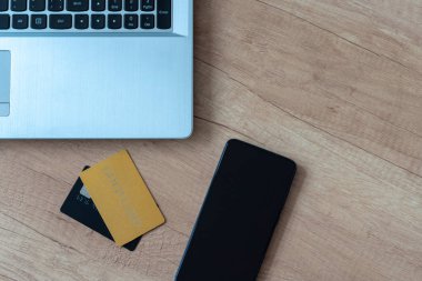 Üst görünüm dizüstü bilgisayar, kartlar, akıllı telefon. İnternet üzerinden konsept alışverişi, internet satışları. İnternetten alışveriş yapmak. Boşluğu kopyala