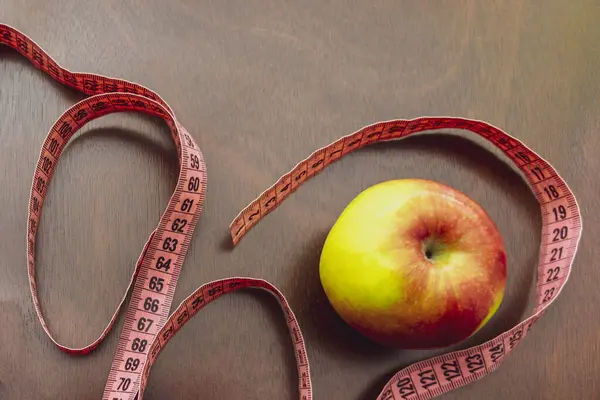 Close up apple, meter tape. Concept Healthy way of life.The first step to a diet and a healthy way of life.