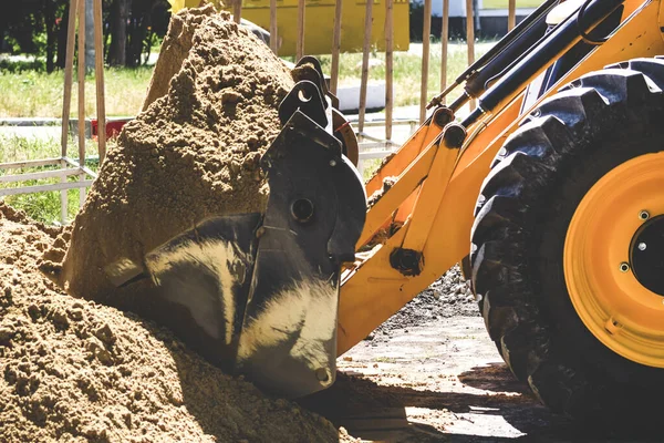 トラクターは砂を漕いでいる 砂で掘削機のバケツ 建設工事のコンセプト — ストック写真