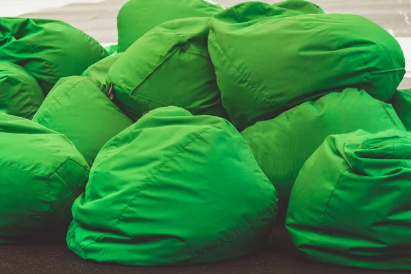 bean bag chairs. a pile of green bags chairs Concept of comfortable  outdoor contemporary furniture. comfortable soft pillows for sitting and lying