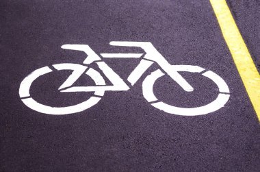  Bisiklet yolu. Bisikletin işareti. Bisiklet yolunda sarı ve beyaz izler var. Bisiklet sembolü