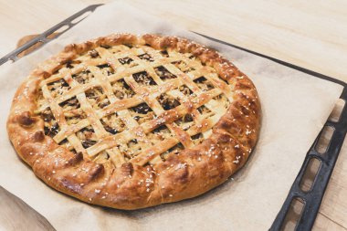 Fırın tepsisinde turta, parşömen. Ev yapımı turta, ev yapımı pişirme konsepti.