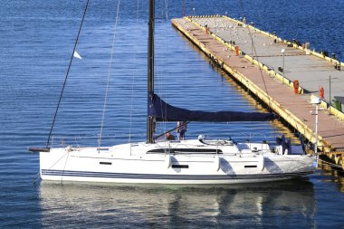 Güneşli bir günde mavi gökyüzünde rıhtıma demirlenmiş bir yat. Yaz tatili. Gezinti. Yaz tatili. Yat, kalkış, tekne, okyanus, deniz